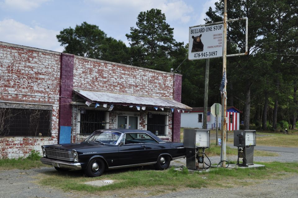 Black 1965 Ford Galaxie parked at an old gas station with a sign for Bullard One Stop