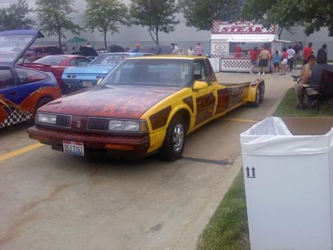 1970 Ford Ranchero - A heavily modified pickup truck with a unique paint job is parked at an outdoor event.