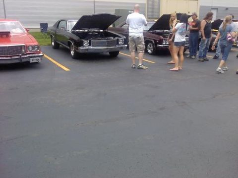 1970 Ford Ranchero - Several vehicles are parked in a lot with their hoods open, with people standing around them.