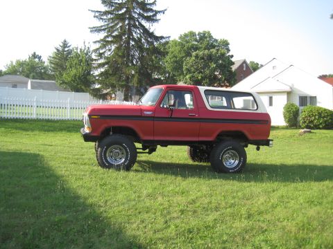 1979 Ford Bronco - This lifted 1979 Ford Bronco, seen from the side, sits on a grassy lawn in front of a residential house.