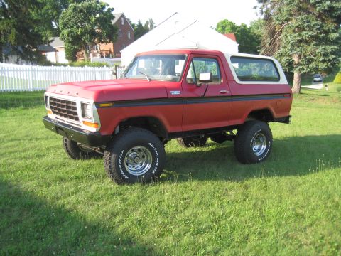 1979 Ford Bronco - This lifted 1979 Ford Bronco sits on a grassy lawn with a white fence in the background.