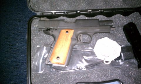1989 Ford Bronco - A pistol with wooden grips is shown inside its protective case.