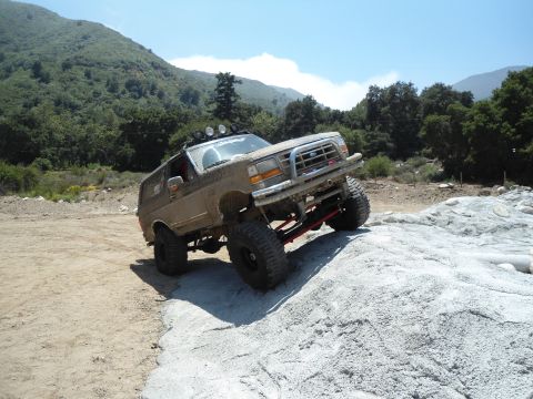 1994 Ford Bronco - This modified 1994 Ford Bronco navigates a challenging off-road course with large tires and a raised suspension.