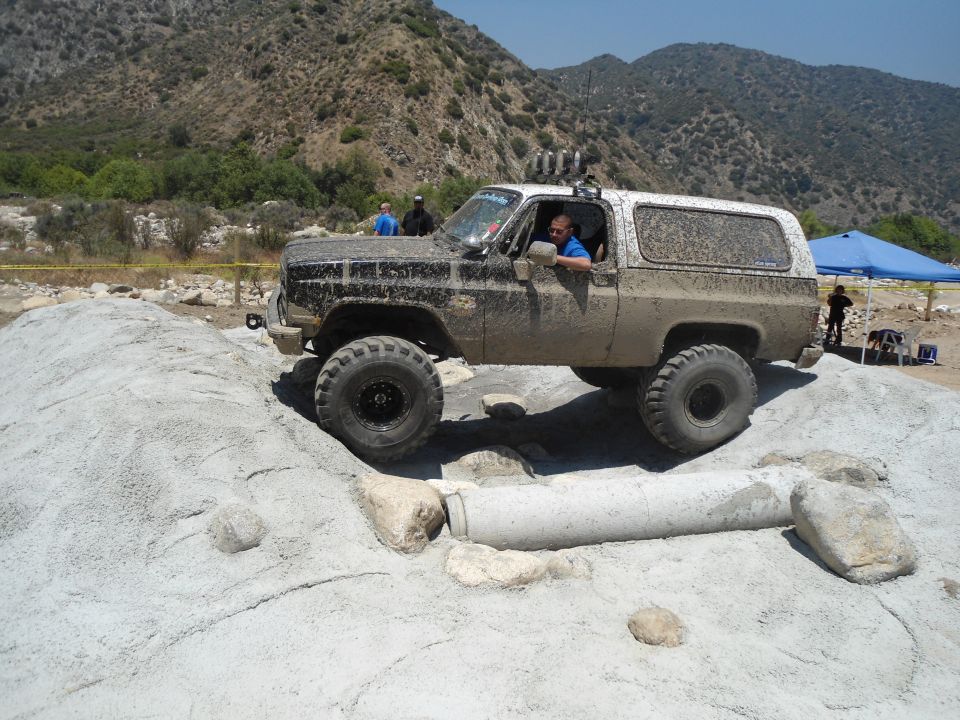 Muddy SUV navigating a rocky obstacle course