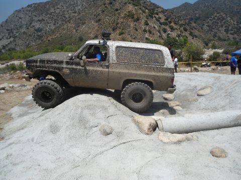 1994 Ford Bronco - This lifted SUV, likely a Chevrolet K5 Blazer from the 1970s, tackles a challenging off-road course.
