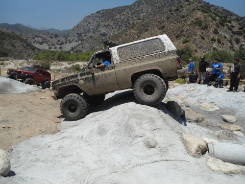 1994 Ford Bronco - Off-road SUV navigates a rocky trail, with another vehicle visible in the background.