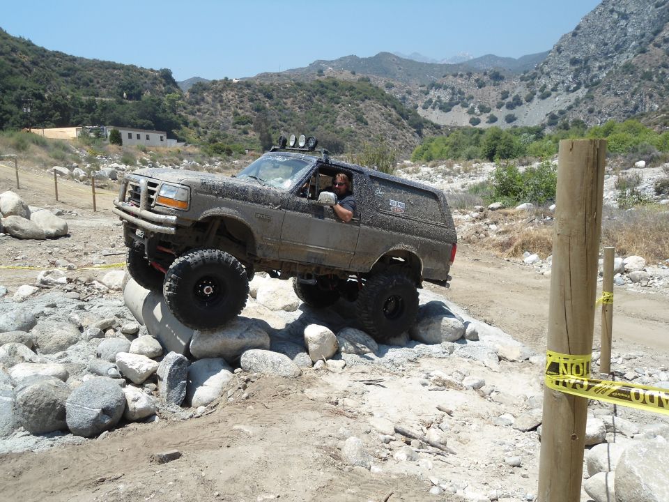1994 Ford Bronco navigating rocky terrain with driver visible