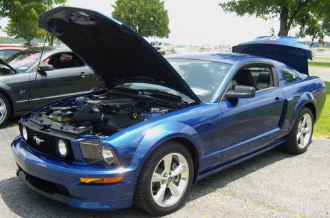 2007 Ford Mustang - Blue Ford Mustang coupe with hood and trunk open, parked next to a grey Ford Mustang GT.