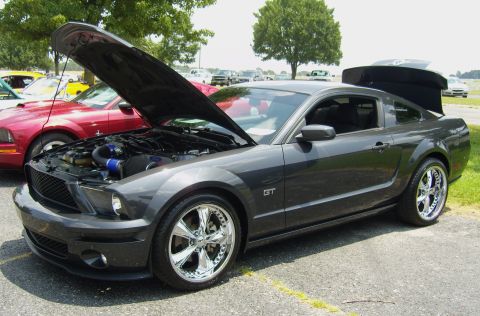 2007 Ford Mustang - A dark gray Ford Mustang GT is displayed with its hood open, revealing the engine bay.
