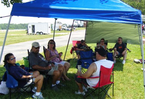 2007 Ford Mustang - People gathered under a canopy at an outdoor event, with trailers in the distance.