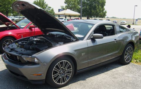 2007 Ford Mustang - A gray Ford Mustang GT is parked with its hood open, alongside another Mustang at an outdoor event.