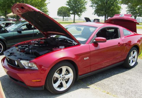 2007 Ford Mustang - A red Ford Mustang with its hood and trunk open is parked next to a dark green car.