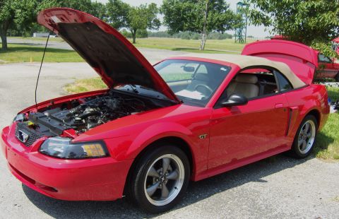 2007 Ford Mustang - Red convertible with hood and trunk open, GT badge visible on fender.