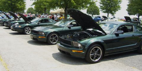 2007 Ford Mustang - A line of Ford Mustangs are displayed with their hoods open at an outdoor event.