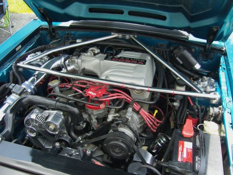 2007 Ford Mustang - The engine bay of a teal 1993 Ford Mustang Cobra shows a 5.0 liter engine with aftermarket modifications.