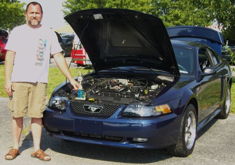 2007 Ford Mustang - Man with trophy poses with his dark blue Ford Mustang at an outdoor car event.