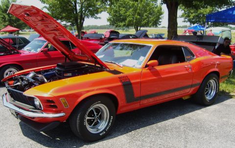2007 Ford Mustang - A classic orange Mustang Boss 302 is displayed with its hood open at an outdoor car show.