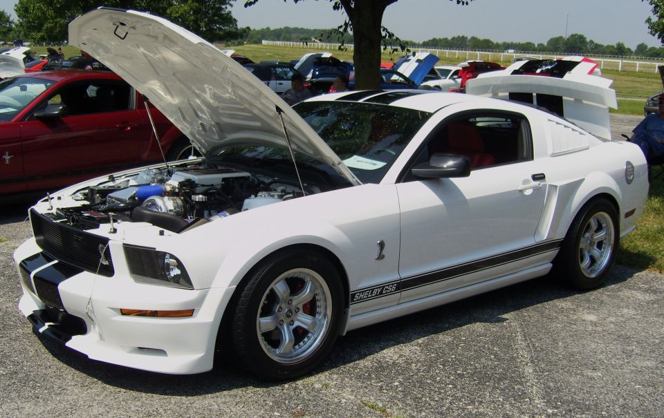 White 2007 Ford Mustang Shelby GT500 with hood open, black racing stripes, and red interior