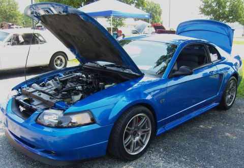 2007 Ford Mustang - A blue Ford Mustang GT is parked with its hood and trunk open, revealing the engine and interior.
