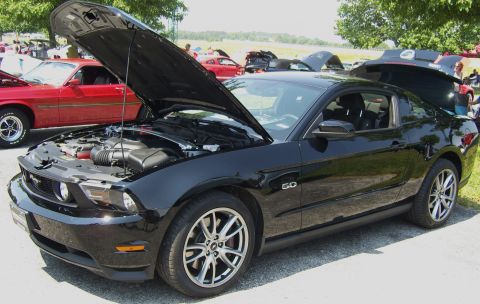 2007 Ford Mustang - A black Ford Mustang is displayed with its hood and trunk open, revealing the engine and interior. The 5.0 badge is visible on the fender.