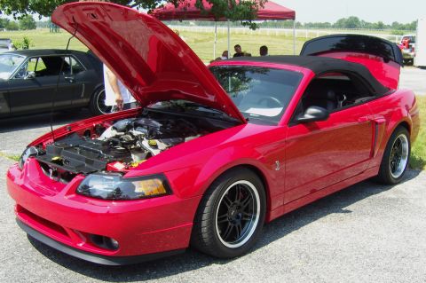 2007 Ford Mustang - Red 2007 Ford Mustang convertible, hood open, parked at an outdoor event with another Mustang.