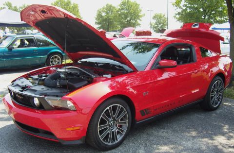 2007 Ford Mustang - A red Ford Mustang GT is displayed with its hood and trunk open at an outdoor event.