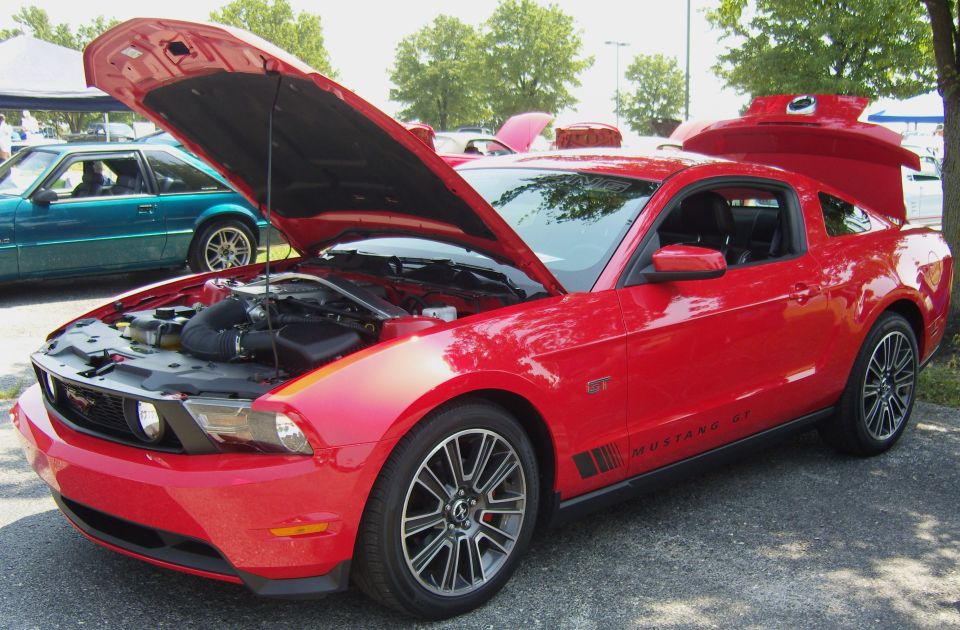 Red Mustang GT with hood and trunk open, parked next to a teal car