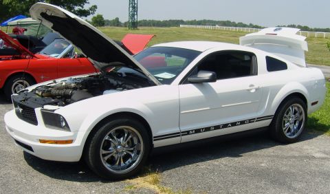 2007 Ford Mustang - A white 2007 Ford Mustang is displayed with its hood and trunk open, parked next to a red car.