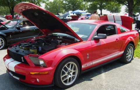 2007 Ford Mustang - Red 2007 Ford Mustang GT 500 at a car show, hood and trunk open.
