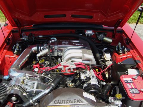 2007 Ford Mustang - Engine bay with chrome intake and supercharger. CAUTION FAN warning label is visible.