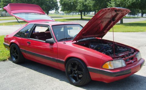 2007 Ford Mustang - This red 1987 Ford Mustang hatchback features black aftermarket wheels and both the hood and trunk are open.