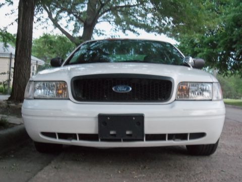 2000 Mercury Grand Marquis - A white 2000 Mercury Grand Marquis is parked on a street, facing the camera directly.