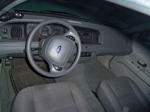 2000 Mercury Grand Marquis - The interior of a Ford vehicle is captured, highlighting the dashboard, steering wheel, and seats.
