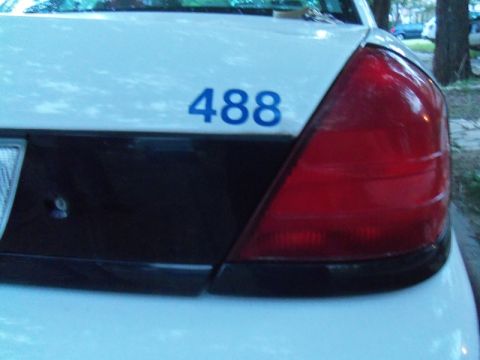 2000 Mercury Grand Marquis - The rear of a white sedan is shown, a black accent panel and the number 488 in blue.