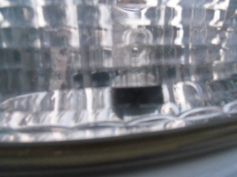 2000 Mercury Grand Marquis - Close-up of a vehicle's headlight assembly, showing the textured lens and internal components.