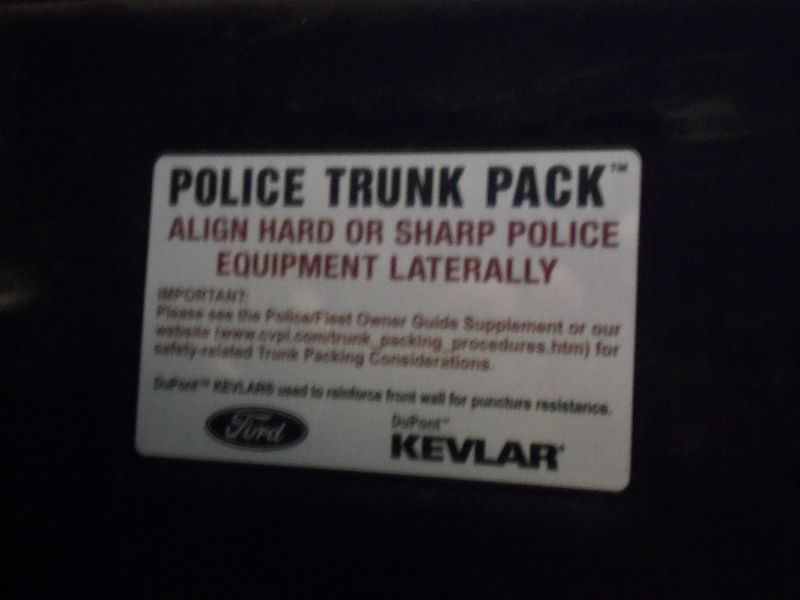 Sticker reads 'POLICE TRUNK PACK' with instructions and Ford and DuPont Kevlar logos