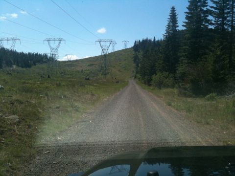 2005 Jeep Wrangler - View from inside a vehicle driving on a gravel road towards power line towers in a wooded area.