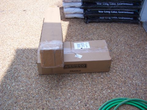1992 Ford Bronco - Cardboard boxes, one labeled Bronco Graveyard, sit on a gravel surface next to bags of mulch.