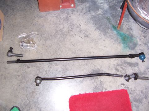 1992 Ford Bronco - Various steering linkage components, including tie rods and ball joints, are displayed on a concrete surface.