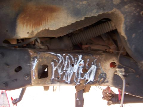 1992 Ford Bronco - Close-up of a heavily rusted vehicle frame with white spray-painted markings.