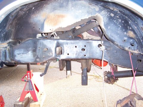 1992 Ford Bronco - The vehicle's undercarriage is visible, supported by jack stands, with suspension and frame components exposed.