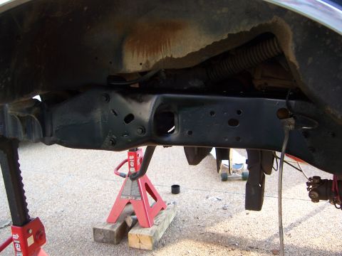 1992 Ford Bronco - Underside view of a vehicle's frame and suspension system, supported by jack stands.