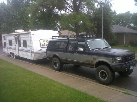 1994 Ford F-150 - This two-tone 1994 Ford F-150 is equipped with a camper shell and roof rack, seen here towing a Wildwood travel trailer.