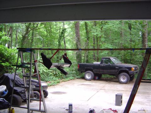 1986 Ford Bronco - A black pickup truck is parked in a driveway with trees in the background.