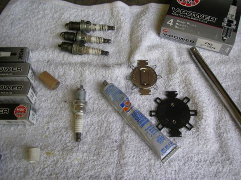 1990 Ford Bronco - Spark plugs, anti-seize, and tools laid out on a towel for engine maintenance.