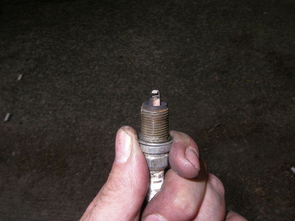 Hand holding a used spark plug