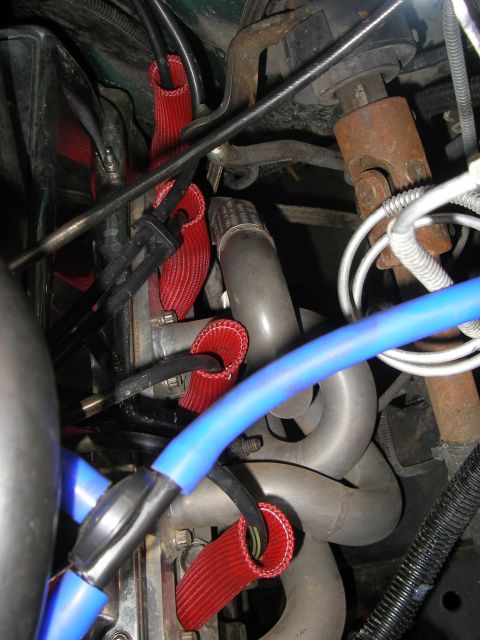 1990 Ford Bronco - Close-up of engine components including spark plug wires and exhaust manifold.