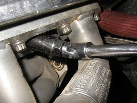 1990 Ford Bronco - A socket wrench is attached to an engine component, with visible text indicating 'BOSSOD MANUFACTURING'.