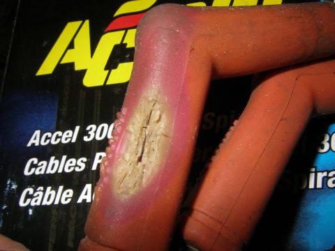 1990 Ford Bronco - Close-up of a damaged spark plug wire boot, showing wear and tear on the insulation.