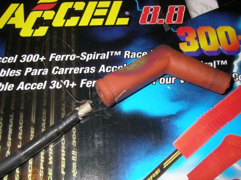 1990 Ford Bronco - A red spark plug wire boot and wire are shown against ACCEL 300+ Ferro-Spiral packaging.